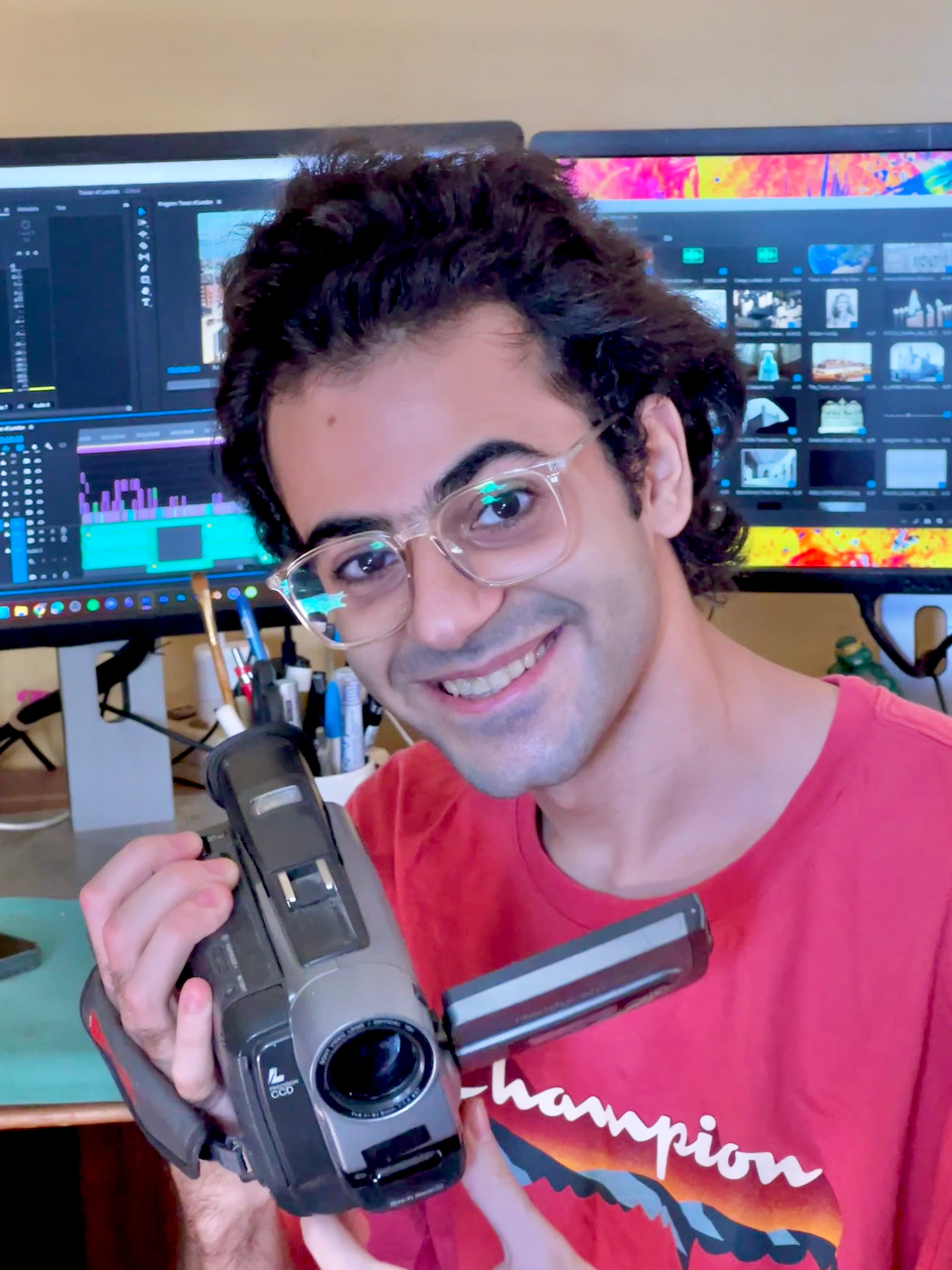 Ali Bahrawy holding a camcorder at his editing desk